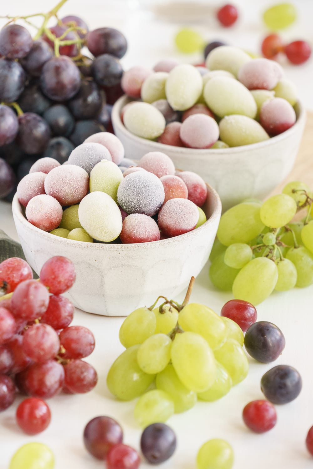 Lots of frozen grapes in 2 bowls.